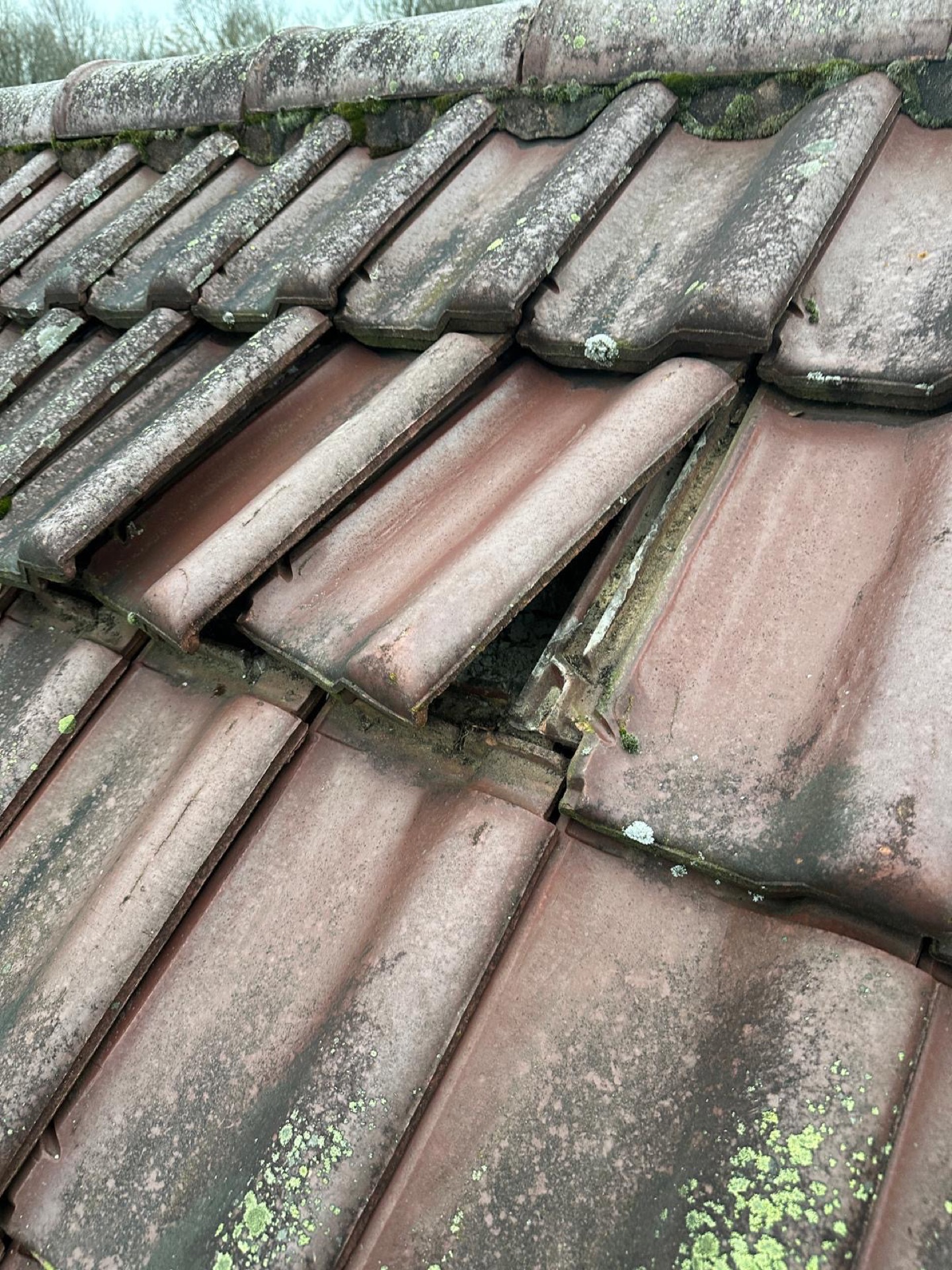 Beschädigte, verschobene Betondachsteine vor der Reparatur